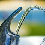 silver faucet with water droplets