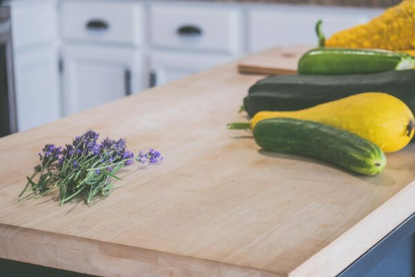 Fresh lavender and courgettes placed on a wooden kitchen counter.